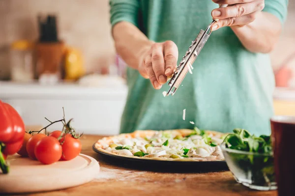 Kvinnan matlagning pizza i köket — Stockfoto