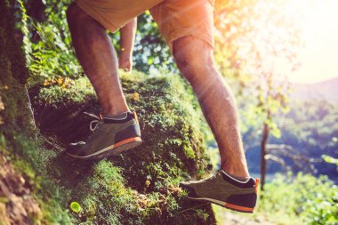 Yosun kaplı kayalar üzerinde tırmanma uzun yürüyüşe çıkan kimse