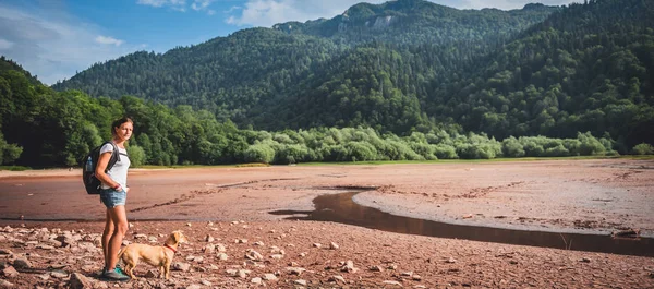 Hembra con perro en lecho de lago seco — Foto de Stock