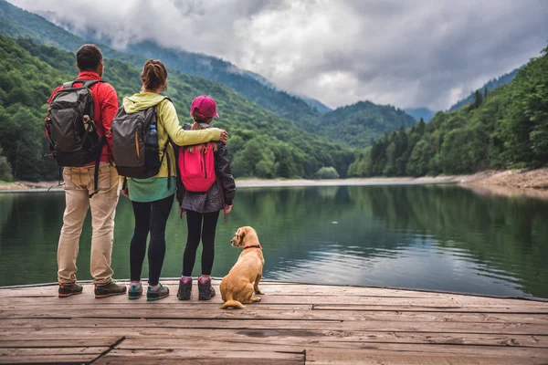 Family with small yellow dog — Stock Photo, Image