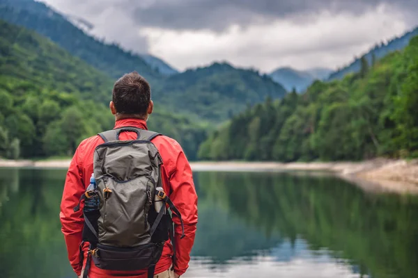 Escursionista in piedi vicino al lago di montagna — Foto Stock