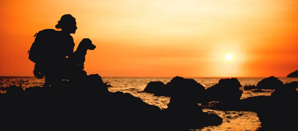 Femme avec chien au coucher du soleil — Photo