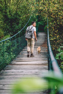 Uzun yürüyüşe çıkan kimse ile küçük sarı köpek