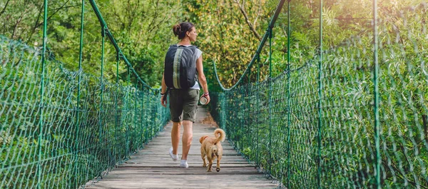 Mujer y perro caminando en el puente —  Fotos de Stock