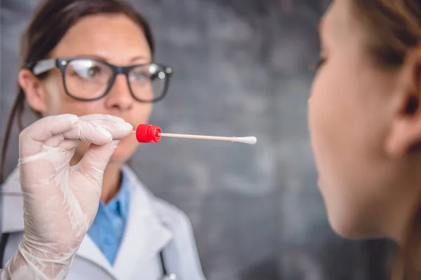 Pamuklu çubuk kullanarak kadın çocuk doktoru — Stok fotoğraf