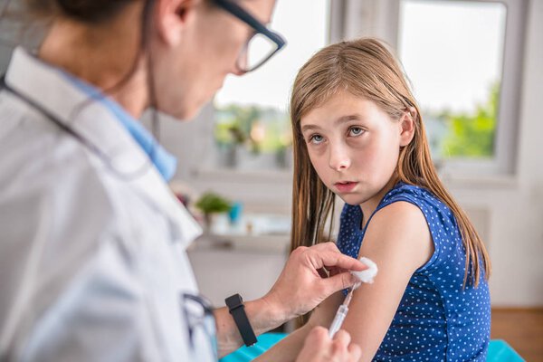Pediatric giving vaccine shot in arm