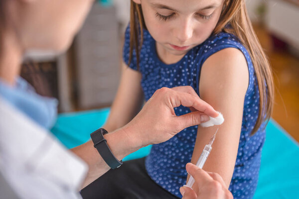 female giving girl vaccine shot