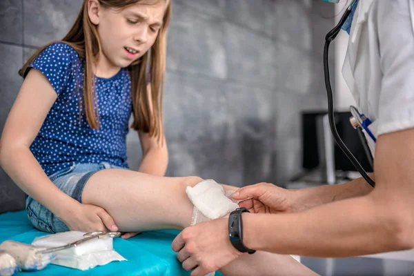 Médico bandagem menina joelho — Fotografia de Stock