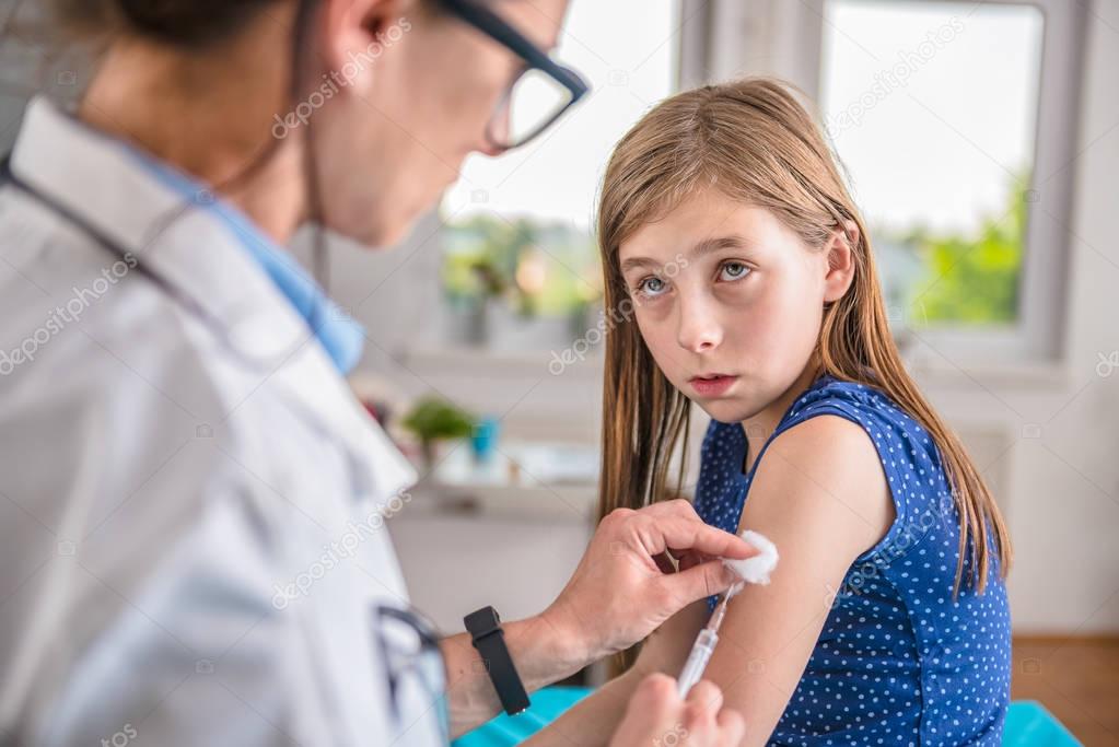 Pediatric giving vaccine shot in arm