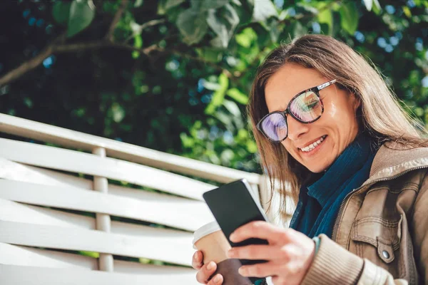 Nő a gazdaság kávé, és a telefon használata — Stock Fotó