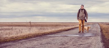 Uzun yürüyüşe çıkan kimse ve köpek yürüyen