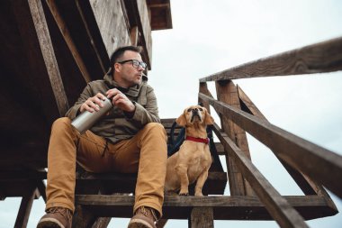 Uzun yürüyüşe çıkan kimse ve merdivenlerde oturan köpek