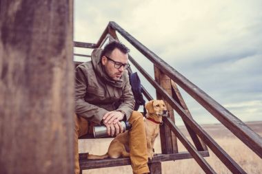 Uzun yürüyüşe çıkan kimse ve oturan köpek
