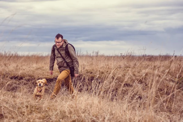 Uzun yürüyüşe çıkan kimse ve küçük sarı köpek — Stok fotoğraf