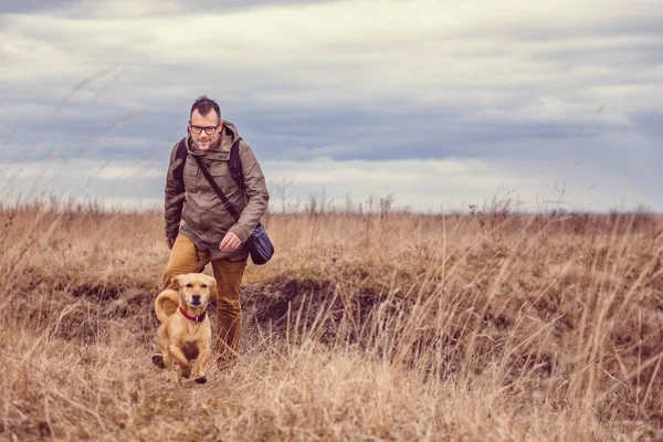 Uzun yürüyüşe çıkan kimse ve küçük sarı köpek — Stok fotoğraf