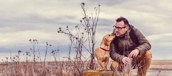 Uzun yürüyüşe çıkan kimse ve yoldan dinlenme köpek — Stok fotoğraf