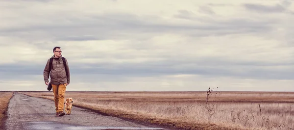 Uzun yürüyüşe çıkan kimse ve köpek yürüyen
