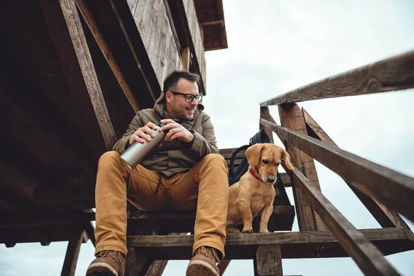 Hiker and dog sitting on stairs — Stock Photo, Image