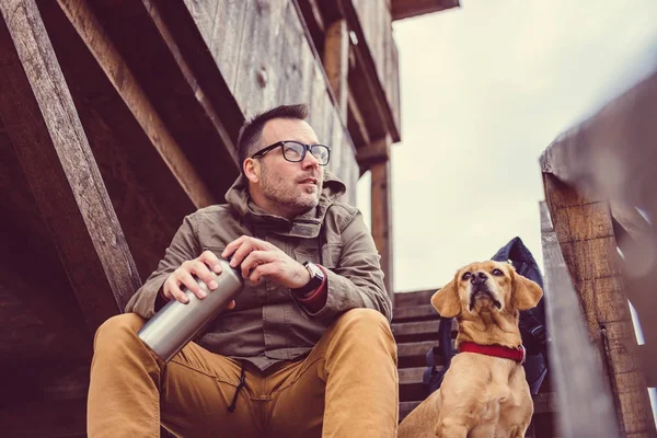 Uzun yürüyüşe çıkan kimse ve merdivenlerde oturan köpek