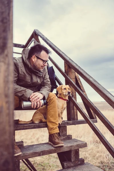 Hiker and dog sitting on stairs — Stock Photo, Image