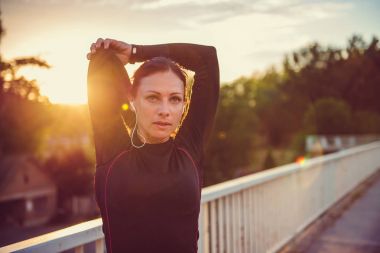 kadının günbatımında germe yapması