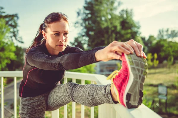 Kvinnan gör stretching på city bridge — Stockfoto