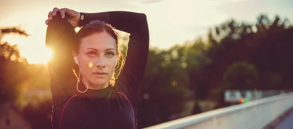 Kvinnan gör stretching på city bridge — Stockfoto