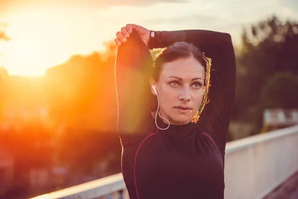 Kvinnan gör stretching vid solnedgången — Stockfoto