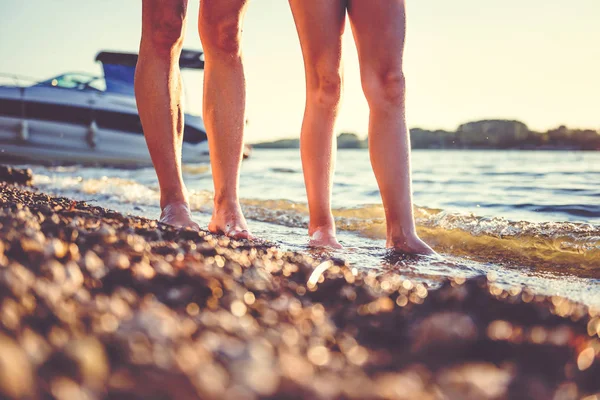 Anne ve kızı gün batımında sahilde