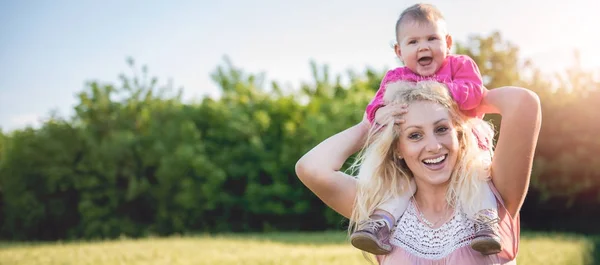 Madre llevando a la hija del bebé a cuestas —  Fotos de Stock