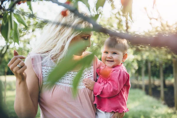Moeder met baby Cherry Picking — Stockfoto