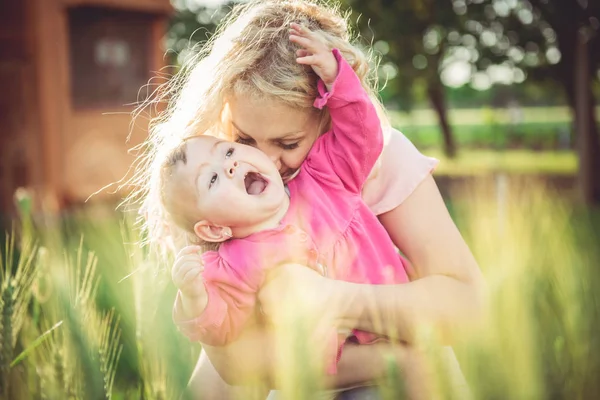 Мать держит и целует ребенка — стоковое фото