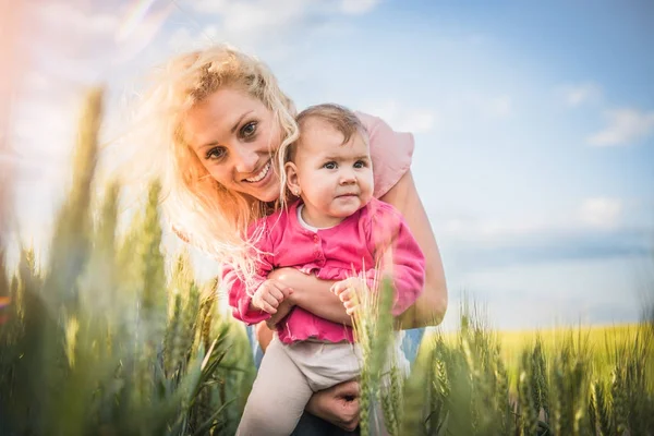 Счастливая мать держит на руках маленькую девочку — стоковое фото