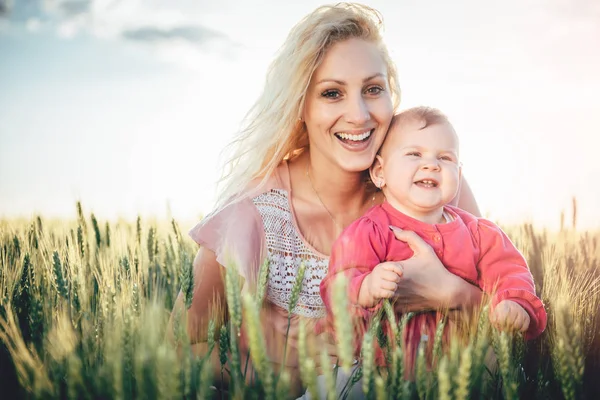 Мать держит девочку в поле — стоковое фото