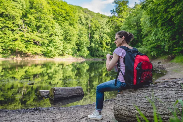 Mujer Sentada Tronco Árbol Junto Lago Sosteniendo Una Botella Agua —  Fotos de Stock