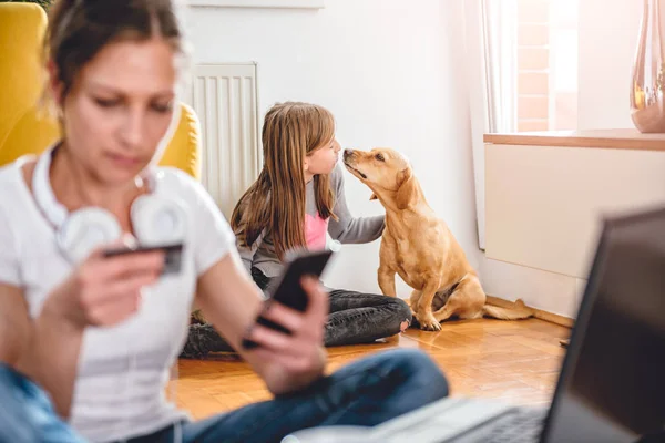 Little Girl Playing Her Dog Home While Mother Shopping Online — Stock Photo, Image