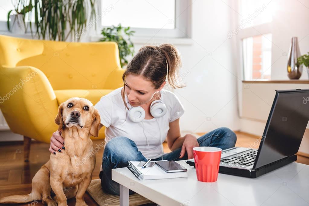 Woman sitting on the floor and Stroking dog at home