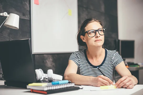 Mujer Con Anteojos Escribiendo Notas Contemplando Oficina — Foto de Stock