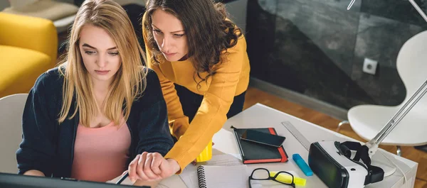 Ofiste çalışan ve bir dizüstü bilgisayar işaret ediyor dizüstü kullanarak iki kadın
