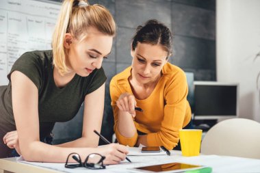 İki iş kadınları ofiste masasında planları kontrol