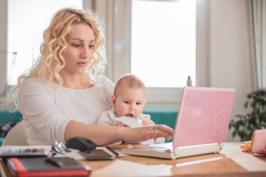 Anne evde çalışma bebeğin Bakımı ve dizüstü bilgisayar kullanarak office