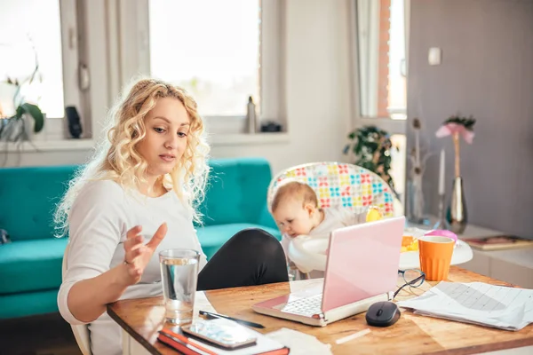 Mãe Sentada Uma Mesa Trabalhando Laptop Com Seu Bebê Alcançando — Fotografia de Stock
