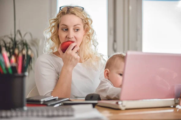 Mama Mananca Mere Rosii Foloseste Laptopul Birou Bebelusul Brate — Fotografie, imagine de stoc