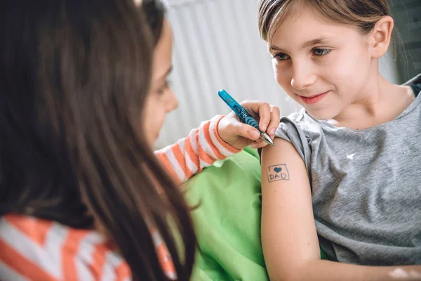 Ragazze che scrivono tatuaggio sul braccio — Foto Stock