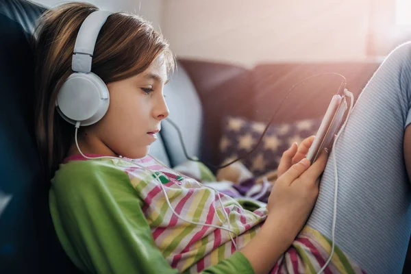 Menina Sentada Sofá Preto Usando Tablet Ouvir Música — Fotografia de Stock