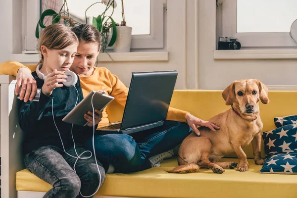 Madre Hija Sentadas Sofá Amarillo Con Pequeño Perro Amarillo Usando — Foto de Stock