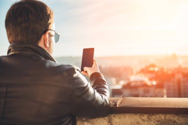 Çatı katında telefonu kullanan adam