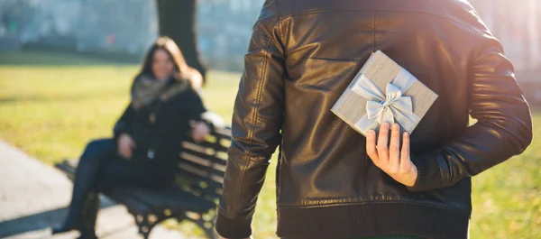 Hombre Sosteniendo Regalo Detrás Espalda Mujer Sentada Banco Del Parque —  Fotos de Stock