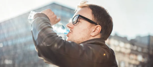 El hombre bebiendo agua en la ciudad — Foto de Stock