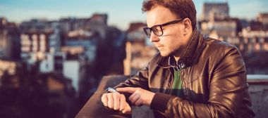 Akıllı izle mavi gökyüzü arka plan üzerinde duran kullanarak gözlük işadamı